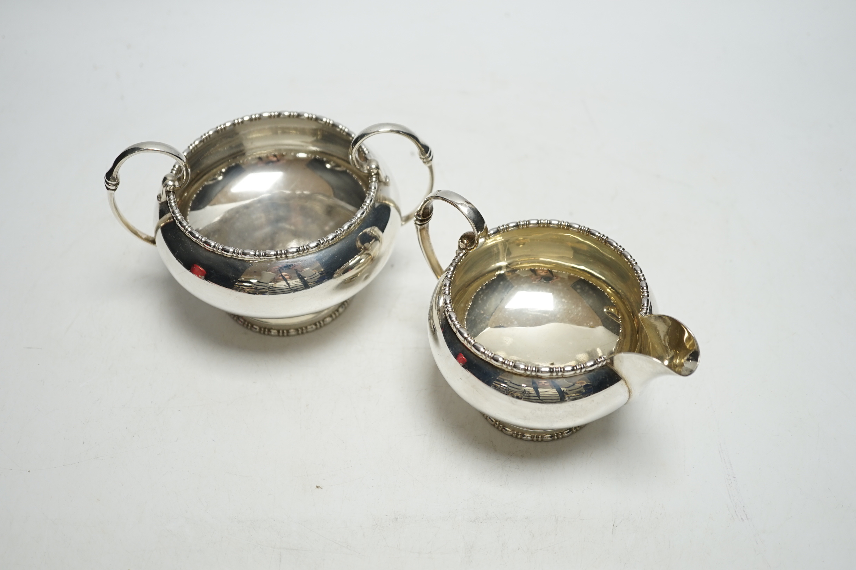 A George VI silver two handled sugar bowl and matching cream jug, Walker & Hall, Sheffield, 1950, 12.8oz.